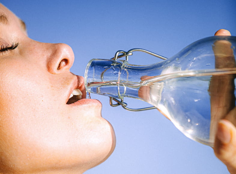 Frau trinkt Wasser, um ihren Durst zu stillen
